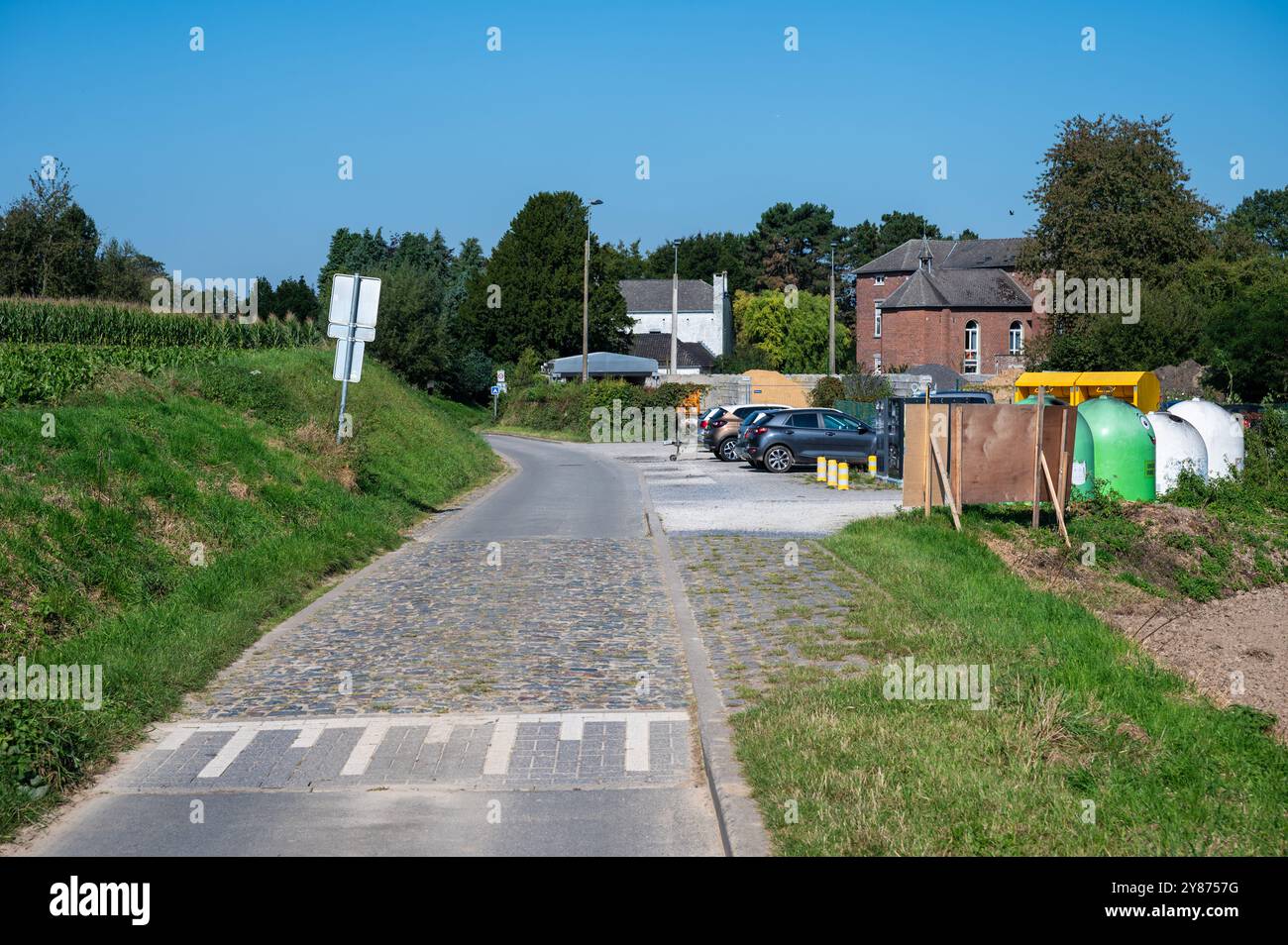 Strada di campagna, case e contenitori per il riciclaggio dei rifiuti di vetro nel villaggio di Gréz, Brabant Wallon, Belgio, 22 settembre 2024 Foto Stock
