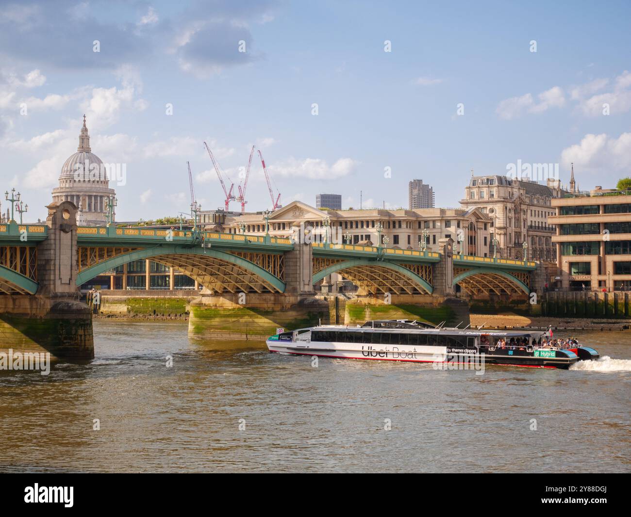 Uber Boat by Thames Clippers, servizio di battello fluviale che passa sotto il Southwark Bridge sul Tamigi, Londra, Regno Unito Foto Stock