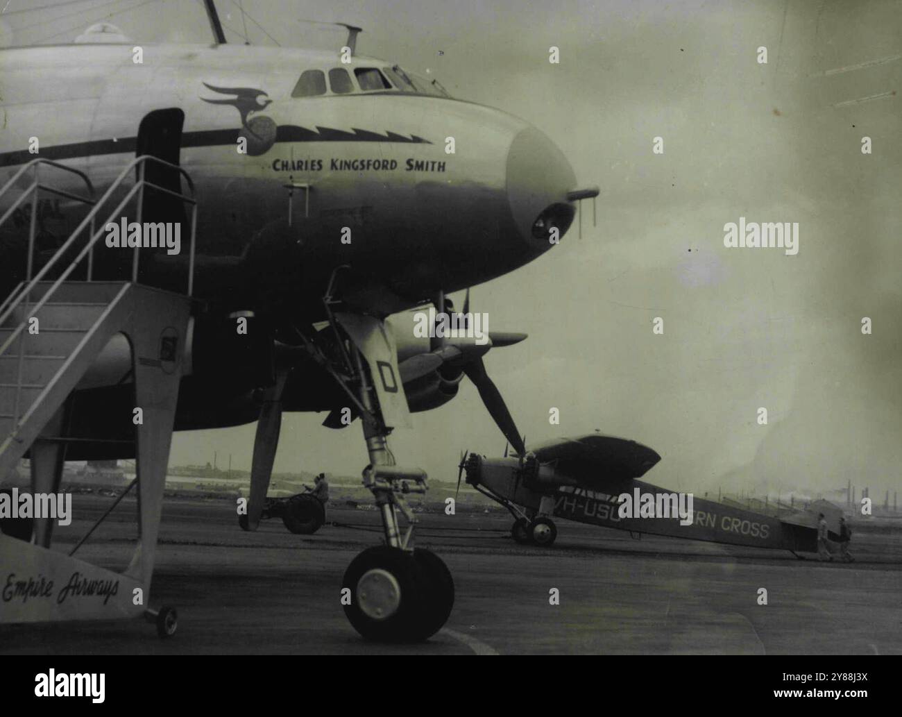 Old and New -- Southern Cross trainata attraverso il Tarmac a Mascot con la Qantas Constellation KCharles Kingsford Smith in primo piano. La Croce del Sud sarà esposta nel nuovo edificio del terminal come pezzo da museo. 28 settembre 1948. Foto Stock