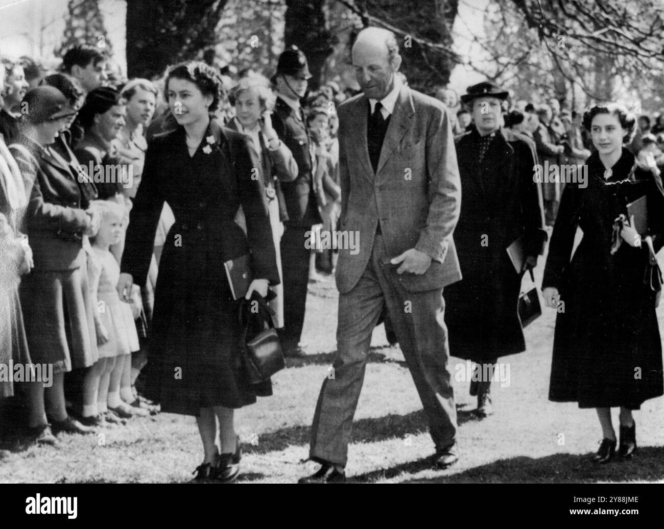 Queen ha visto i processi olimpici di Badminton -- la regina sorride alla folla mentre cammina con la principessa Margaret e il duca di Beaufort per assistere all'evento di dressage durante i tre giorni di Badminton, Gloucestershire, alle prove olimpiche dei cavalli di giorno (mercoledì). 22 aprile 1953. (Foto di Reuterphoto). Foto Stock