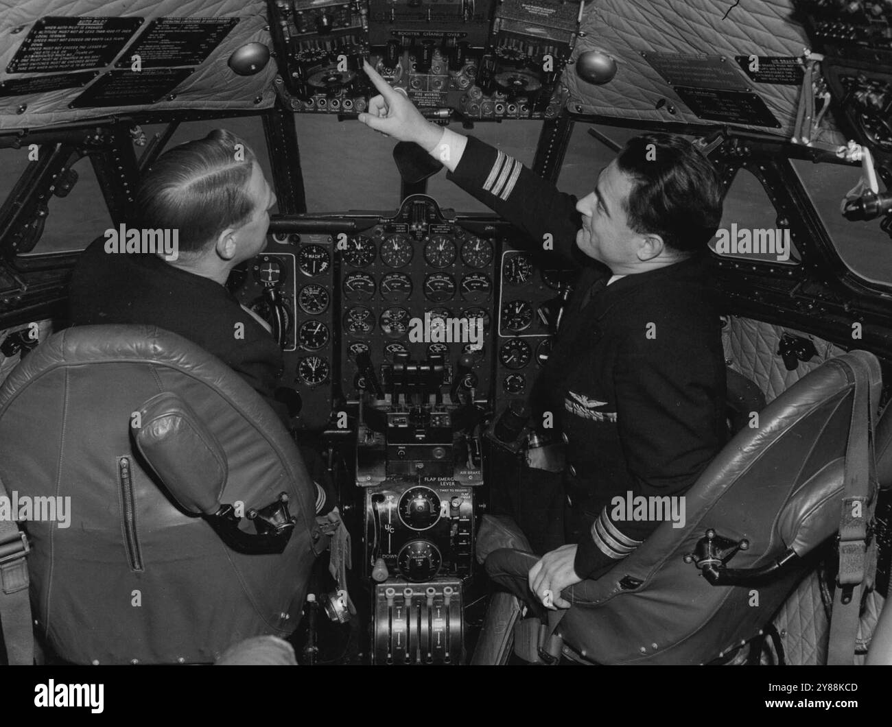 Si allenano per gestire gli aerei di linea più veloci del mondo -- tra pochi mesi la BOAC inaugurerà il loro servizio di jet Airliner Comet - il primo al mondo - e un'unità di addestramento che è stata istituita all'Aeroporto di Londra è impegnata a girare ***** schianto aereo che sarà pienamente abituato alla gestione degli aeromobili molto veloci con il massimo ***** . Qui uno degli istruttori, il capitano Ernest Rodley, di ***** , Familiarizza il capitano Trevor Marsden con il ***** Nella cabina del pilota Comet. 27 febbraio 1952. Foto Stock