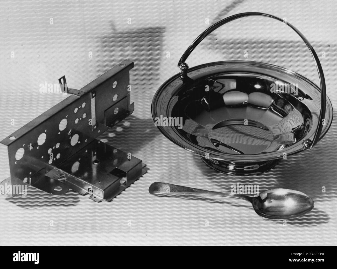 Ricerca internazionale sull'uso dello stagno: I laboratori in Gran Bretagna servono il mondo -- nuove leghe placcature sviluppate dall'Istituto di ricerca dello stagno e ora in uso commerciale: Stagno-Zine come rivestimento anti-corosione per telai radio. La placcatura in stagno-nichel su un recipiente di frutta in ottone non necessita di lucidatura meccanica dopo la deposizione e il tono più caldo e piacevole del cromo. Il cucchiaio è rivestito con 'Speculum', una lega di rame-stagno ora disponibile come rivestimento placcato, ma utilizzata in precedenza in epoca greco-romana e nell'antica Cina sotto forma di specchi fusi da cui il nome. 14 maggio 1953. (Foto dell'ufficio centrale di informat Foto Stock
