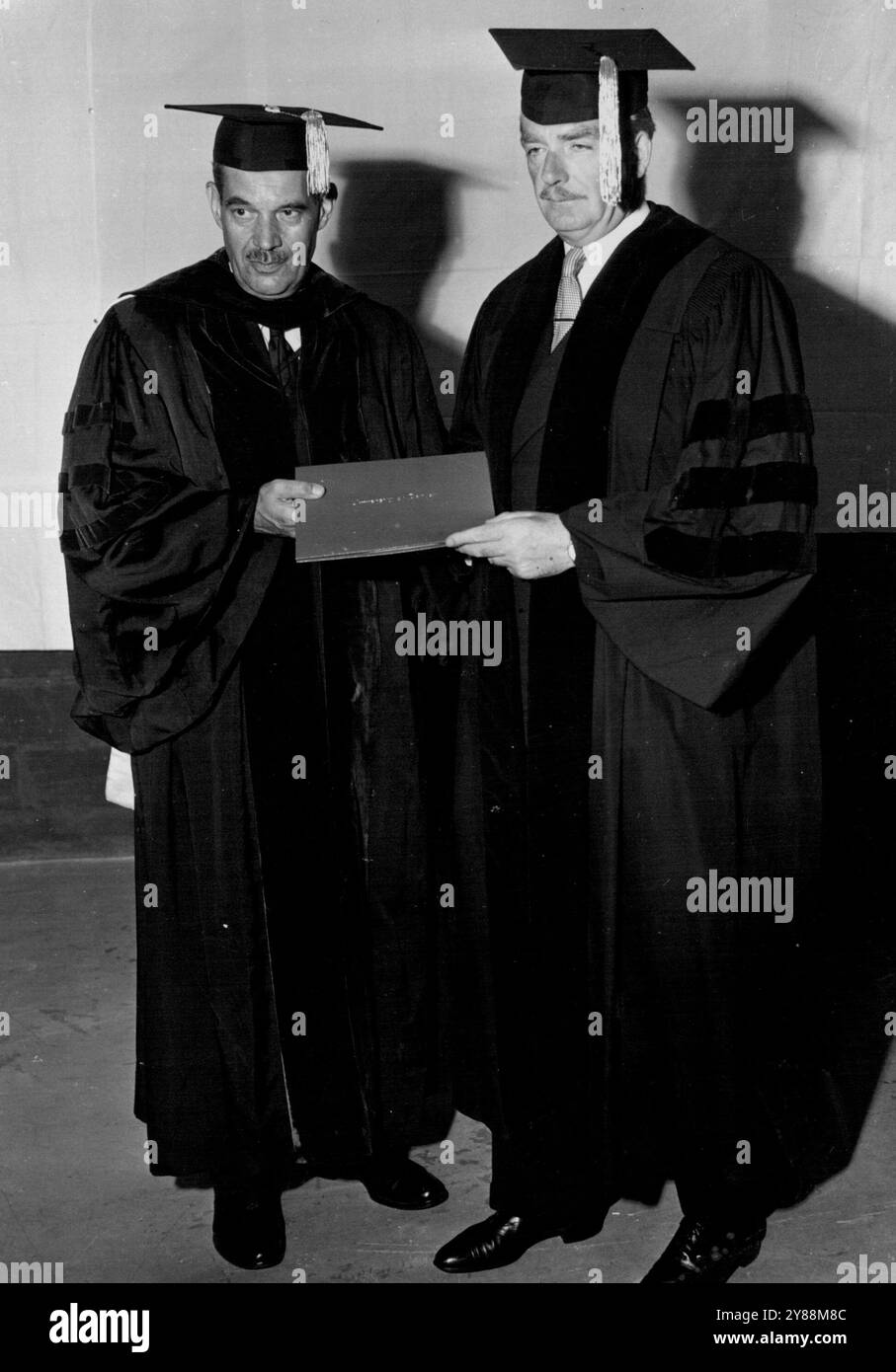 Vestito con il berretto tradizionale, Mr. Eden (a destra) si laurea presso Albert C. Jacobs, Cancelliere dell'Università di Denver. Durante la sua recente visita negli stati Uniti d'America, Anthony Eden, ex ministro degli Esteri britannico, si è rivolto a una sessione del World Affairs Institute presso l'Università di Denver, a Denver, Colorado. Mentre era all'università, il signor Eden ha ricevuto una laurea honoris causa di medici di servizio pubblico. L'istituto è stato condotto durante l'osservanza del 25° anniversario della fondazione di scienze sociali dell'università. Leader diplomatici, aziendali e governativi Foto Stock