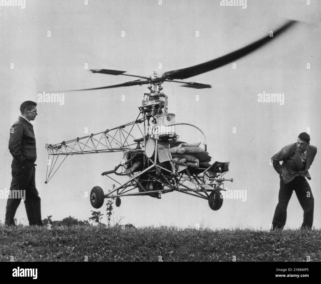 L'elicottero vola da solo -- l'elicottero vola da solo qui mentre due piloti collaudatori lo osservano volare appena sopra il suolo. Stanley Hiller, giovane inventore, afferma che il nuovo modello è "intrinsecamente stabile" in quanto tenderà a rimediare se stesso se tirato da una raffica di vento. Ha detto che la stabilità si ottiene grazie ai due bracci corti aggiuntivi nel rotore, montati ad angolo retto rispetto alle pale del rotore normali. 29 gennaio 1948. (Foto di AP Wirephoto). Foto Stock