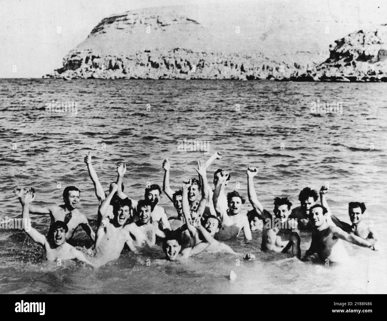 Le truppe australiane si tuffano nella nuotata -- le cime australiane hanno approfittato della vicinanza dell'acqua di mare dopo la caduta di Bardia, porto libico caduto in mano agli inglesi durante la campagna del Nord Africa. Qui c'è un gruppo di australiani che si divertono e lavano via un po' della polvere del deserto nel porto di Bardia. 18 febbraio 1941. (Foto di Associated Press Photo). Foto Stock