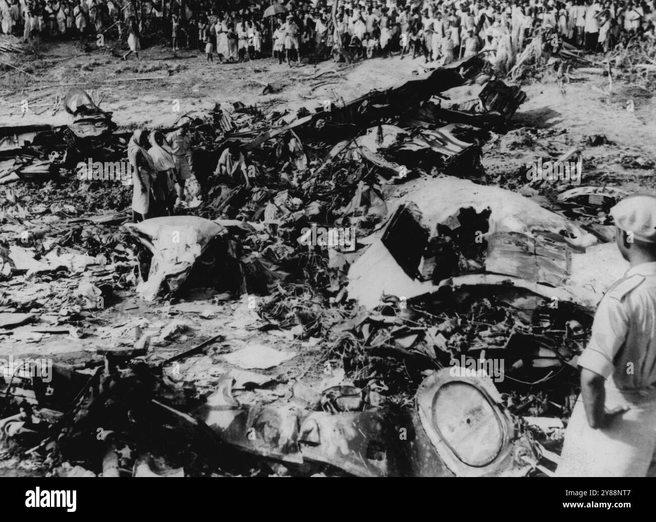 Crashed Comet Village Women Help in Salvage Job -- Una grande folla guarda come le donne del villaggio aiutano nelle operazioni di salvataggio in mezzo al relitto distrutto della B.O.A.C. Comet che si è schiantata a circa 25 miglia da Calcutta con la perdita di 43 vite. L'incidente è avvenuto sabato scorso. 7 maggio 1953. (Foto di United Press Photo). Foto Stock