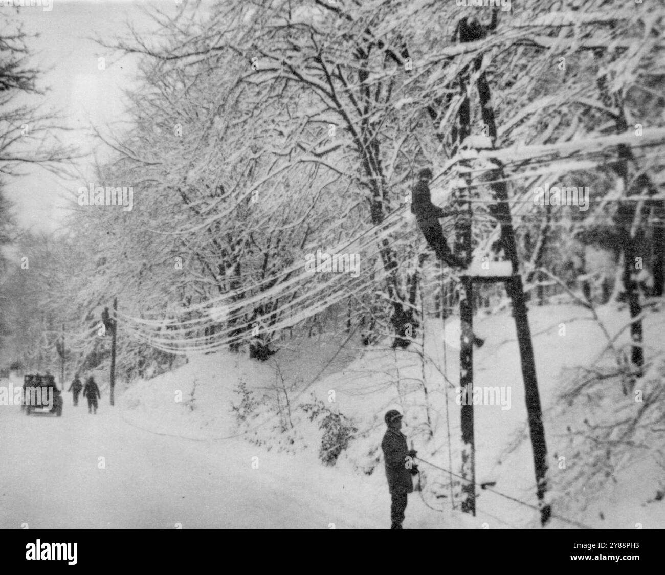 Yanks String Communication Lines -- Lineman americani delle linee di comunicazione ad arco della prima Armata in una zona innevata del fronte belga. 15 gennaio 1945. (Foto di Associated Press Photo). Foto Stock