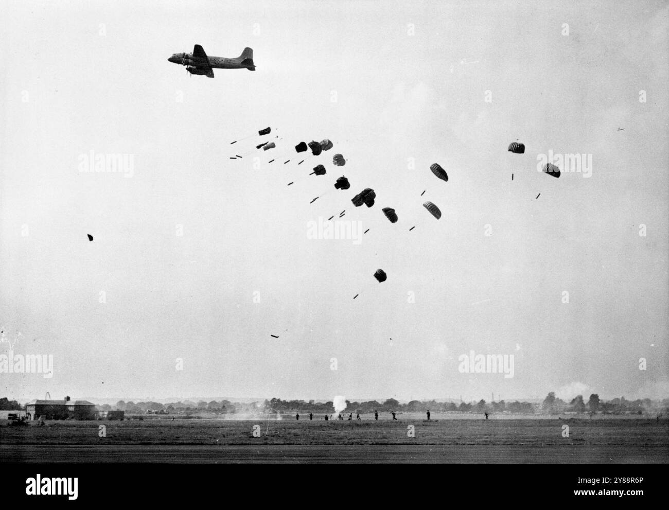 King and Queen at R.A.F. display: A Handley Page "H as Tings" lancia le armi con i paracadute ai "prigionieri in fuga" dopo gli Amiens. Il muro della prigione è stato violato dalle Mosquitos alla RAF display. Il re e la regina oggi hanno guardato la Royal Air Force attraverso i suoi passi alla RAF display. Farnborough, rianimato dopo 13 anni. Uno dei momenti salienti dello spettacolo è stata la rievocazione dell'audace incursione nella prigione di Amiens, quando Misquitoes, volo basso, liberò il francese imprigionato violando le mura della prigione. Più di ***** anche 220 aerei stanno prendendo parte a un flypast massivo. 7 luglio 1950. (Foto di Fox P Foto Stock