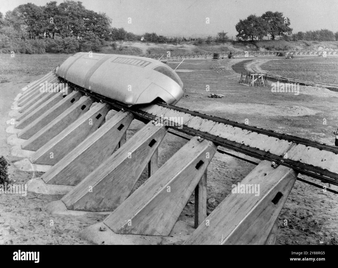 Il treno "Drape" - per risolvere i problemi del traffico mondiale -- il treno Alweg, composto da due motori e un pullman passeggeri, che corre su un unico binario. L'evolutiva monorotaia Alweg di 200 km/h, progettata da ingegneri tedeschi per risolvere i problemi di traffico nel mondo, è stata programmata per la prima volta nei campi vicino a colonia in Germania, oggi (mercoledì). A guardare c'erano gli ingegneri di Los Angeles, che progettano il primo sistema monorotaia su larga scala al mondo se il test ha avuto successo. L'alluminio ad azionamento elettrico; treno in lega, sagomato come un vagone della metropolitana di Londra, ma sovrastante il binario singolo, si aggancia Foto Stock