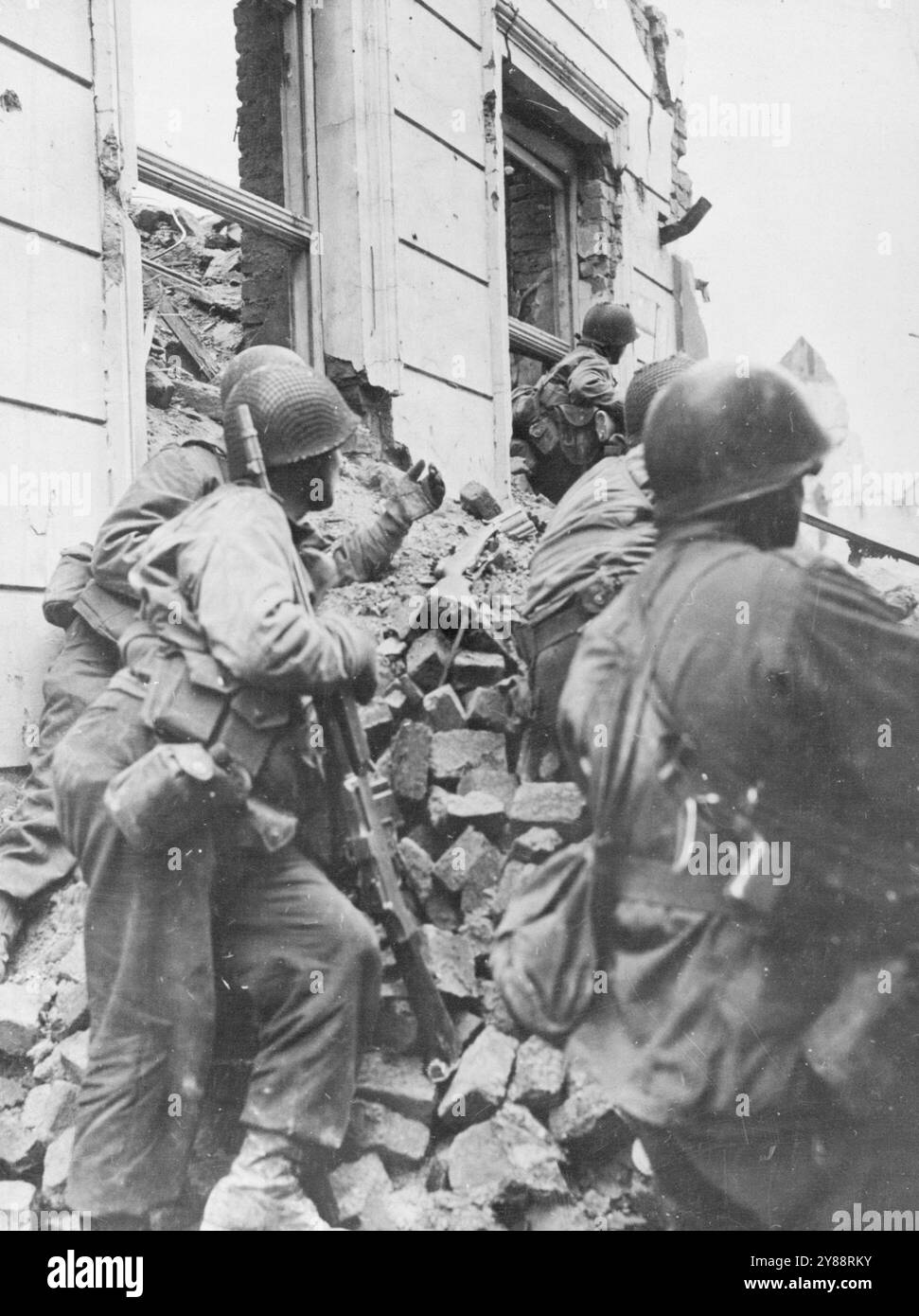 Fanti statunitensi Battaglia in Rubble -- fanti di Colonia della 104a Divisione, la prima Armata degli Stati Uniti, si rifugiano dietro un mucchio di macerie durante i pesanti combattimenti di strada che precedettero la cattura di Colonia, in Germania, il 6 marzo 1945. Colonia, la terza città più grande della Germania e capitale della Renania, fu piena di macerie quando le truppe americane assaltarono per le strade. 23 aprile 1945. (Foto di U.S. Signal Corps Photo). Foto Stock