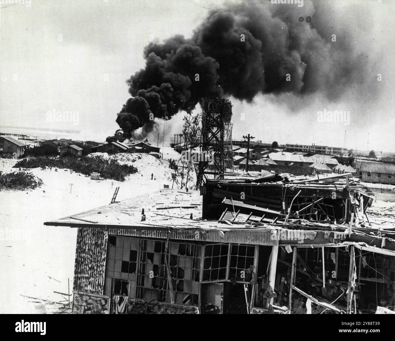 Jap Damage a MidwaySmoke sorge da un incendio incendiato da un bombardiere in picchiata Jap che ha fatto irruzione a Midway all'inizio di giugno. L'edificio in primo piano e' stato distrutto dalla portaerei, aerei di base che hanno preso parte allo stesso assalto. Una forza di aerei da combattimento del corpo dei Marines "malamente in inferiorità numerica" ingaggiò gli aerei Jap e con l'aiuto del fuoco di terra distrusse più di 40 degli aerei attaccanti. Il raid Jap ha causato danni seri ma "non disabilitanti". 7 settembre 1942. (Foto di Associated Press Photo). Foto Stock