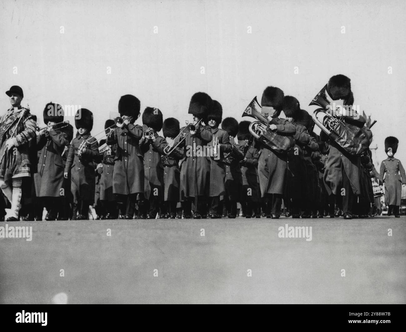 Questa insolita vista delle Grenadier Guards dà quasi l'impressione che siano da qualche parte in servizio attivo. In effetti, è un primo piano della mano e il maggiore Miller, il direttore musicale, che sta marciando al loro fianco. In realtà, la Band è a pochi metri da Buckingham Palace, e un assaggio della figura sulla statua della Regina Vittoria può vedere appena dietro il maggiore Miller. La Grenadier Guards Band visiterà a breve l'Australia. 1° ottobre 1934. Foto Stock