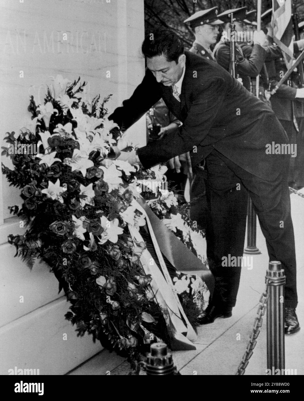 Omaggio dal Messico -- Miguel Aleman, presidente del Messico, getta una corona sulle pendici del soldato sconosciuto d'America oggi al cimitero nazionale di Arlington. Soldati statunitensi (retroguardia) di Una guardia colorata, con la bandiera americana. 30 aprile 1947. (Foto di AP Wirephoto) Foto Stock