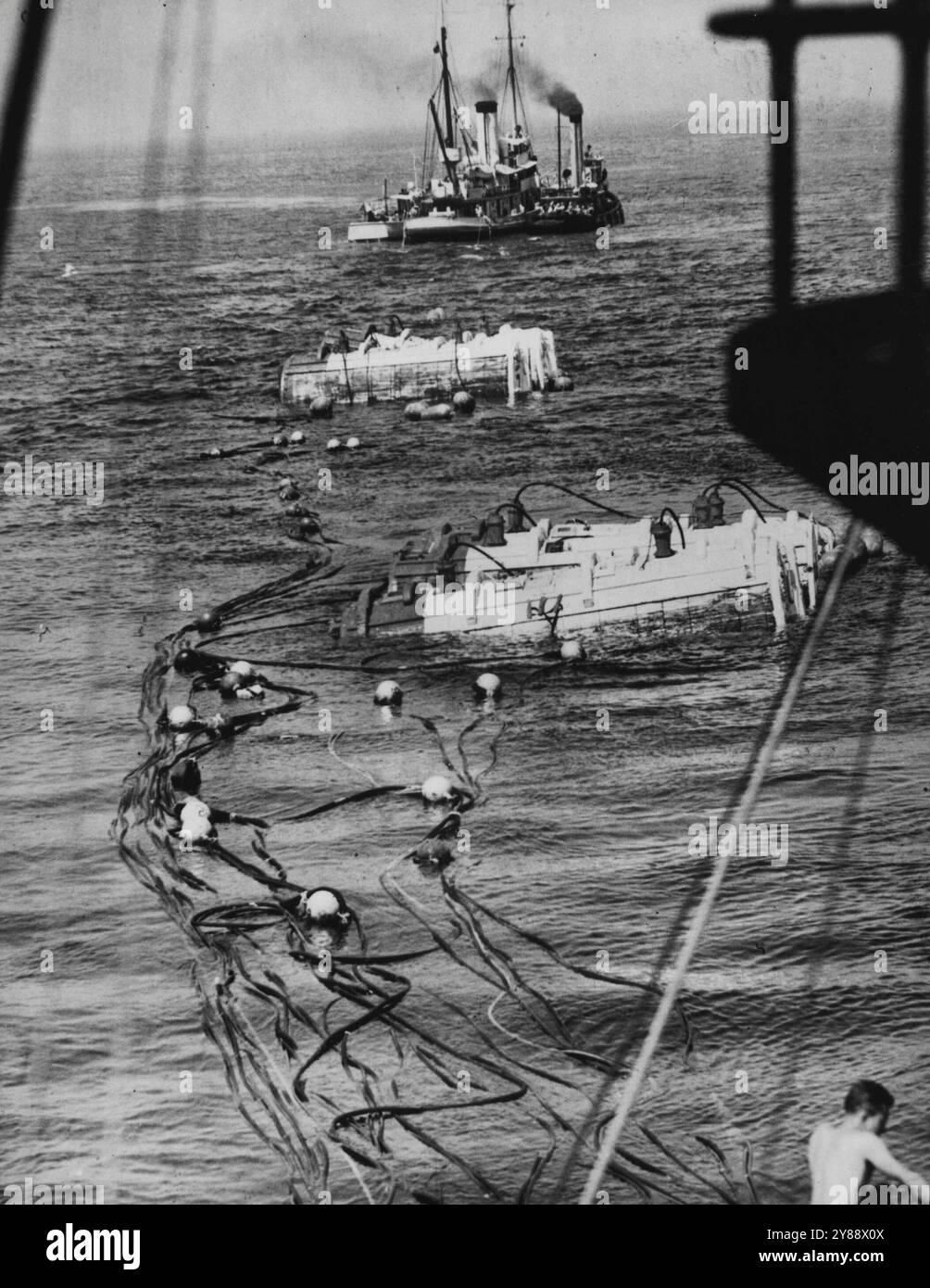 Wandank tota il sottomarino sommerso a Shallow Water -- sei Pontoni, prua e poppa, che sono venuti in superficie quando gli squadroni del sottomarino sono stati sollevati dal letto dell'oceano 80 piedi. Si noti che la grande quantità o linee che vanno dal falco, in primo piano, ai Pontoon, l'acqua wan può essere vista sul fondo del terreno mentre si trainano i cigolii sommersi sommersi. 13 agosto 1939. (Foto di Wide World Photos). Foto Stock