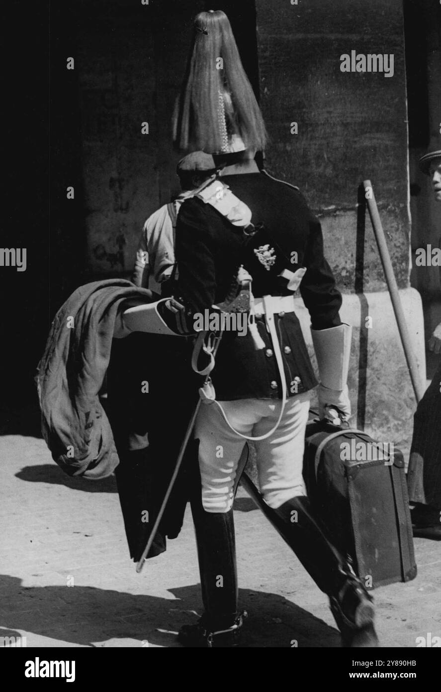 Le guardie a cavallo cambiano - senza cavalli -- vista inusuale mentre un Horse Guard cammina con il suo kit mentre gli operai si preparano per le modifiche ecc.. A causa delle alterazioni alle scuderie delle Horse Guards, il cambio viene effettuato senza cavalli. 13 agosto 1951. (Foto di Daily mail Contract Picture). Foto Stock