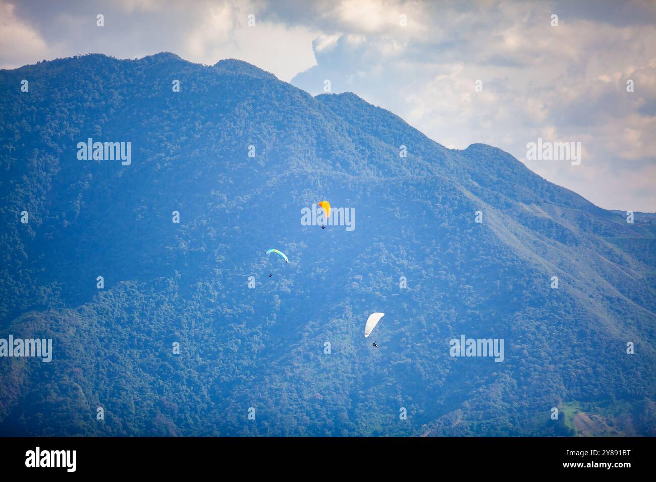 Persone che navigano in parapendio sulle splendide montagne del dipartimento di Antioquia in Colombia. Parapendio tandem. Concetto di sport estremi. Foto Stock