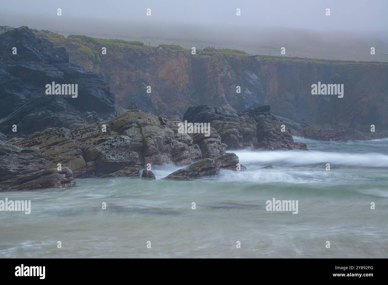 Scogliere costiere Foggy a Clogher Beach, penisola di Dingle Foto Stock