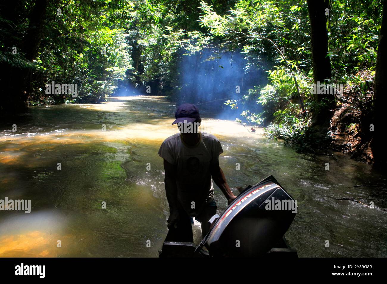 Un automobilista che spinge la barca a muoversi in acque poco profonde nel fiume, attraverso la foresta abituale di Dayak IBAN nel Kalimantan Occidentale, Indonesia. Foto Stock