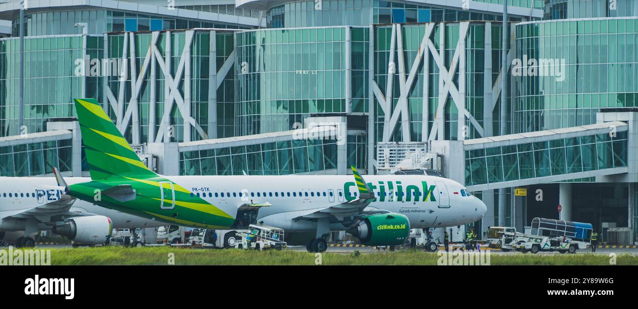 Balikpapan, Indonesia - 26 settembre 2024. Un jet Citilink passeggeri parcheggiato al terminal dell'aeroporto di Balikpapan. L'aereo è circondato dall'equipaggio di terra A. Foto Stock