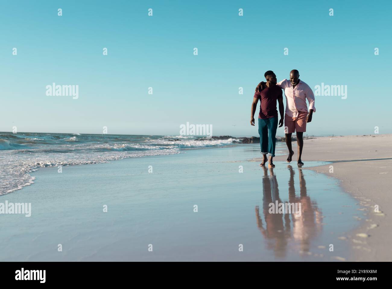 Senior afroamericano e afroamericano che si godono una passeggiata sulla spiaggia Foto Stock