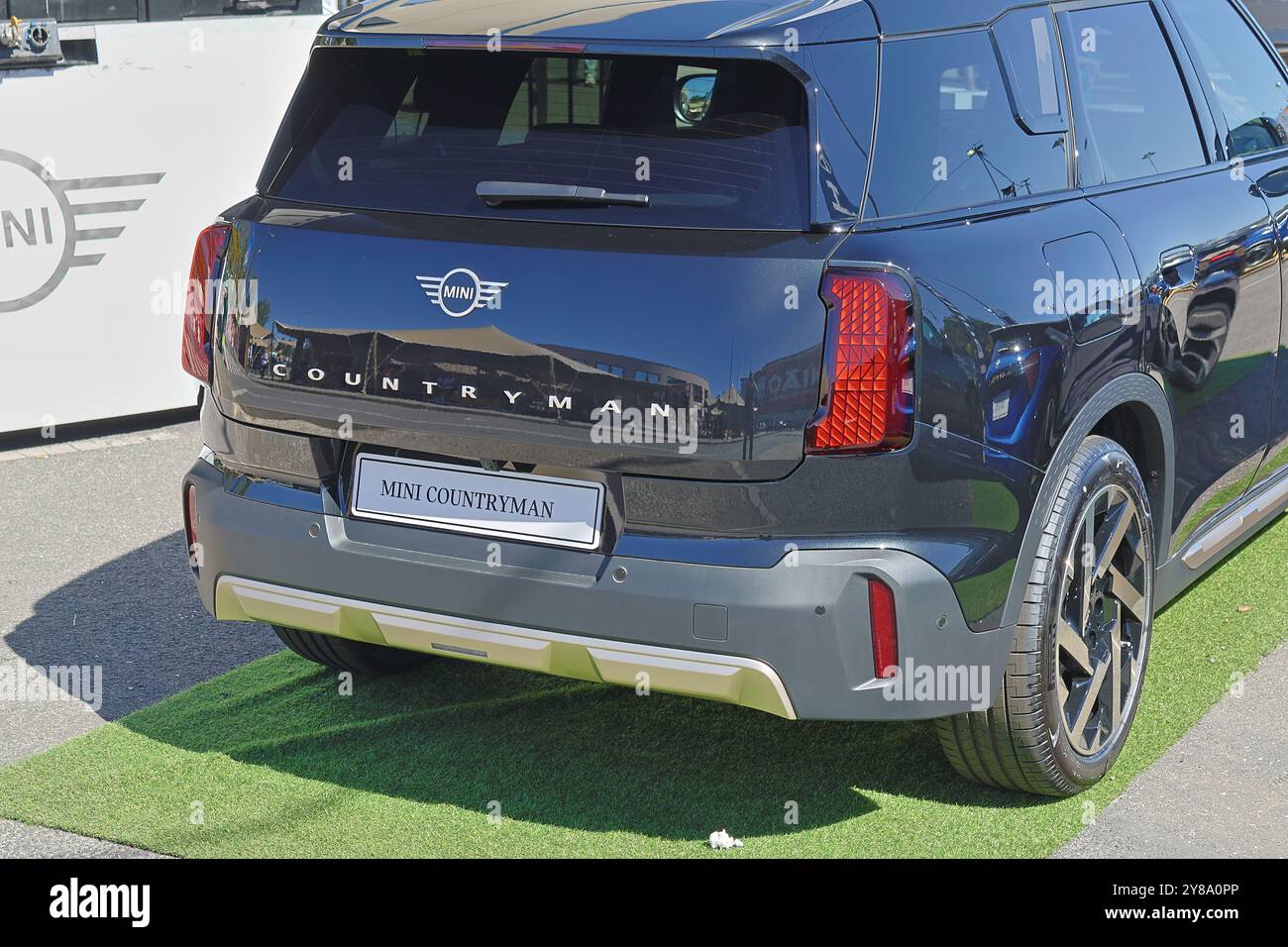 Il mini contadino nero è parcheggiato su un'erba verde, che presenta un design elegante e caratteristiche moderne Foto Stock