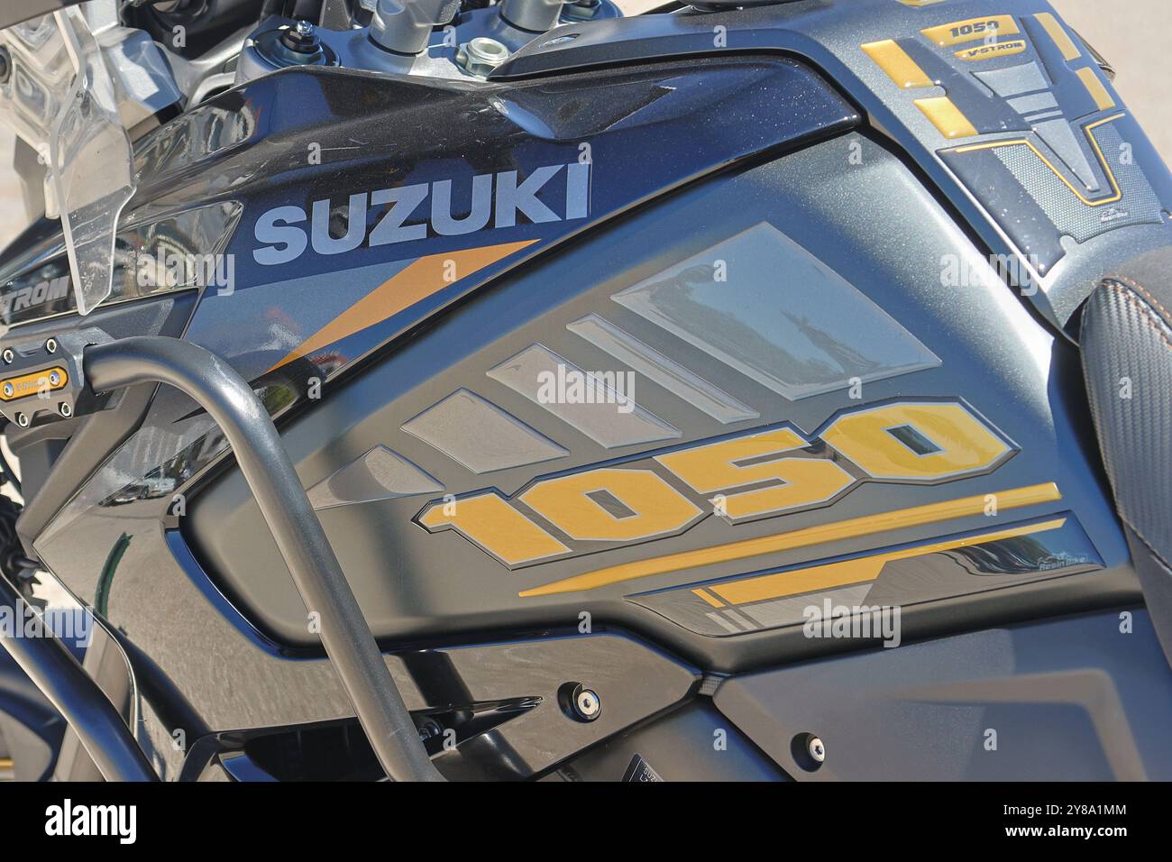 Vista ravvicinata del logo suzuki e della designazione del modello su un serbatoio del carburante per motociclette nero e giallo Foto Stock