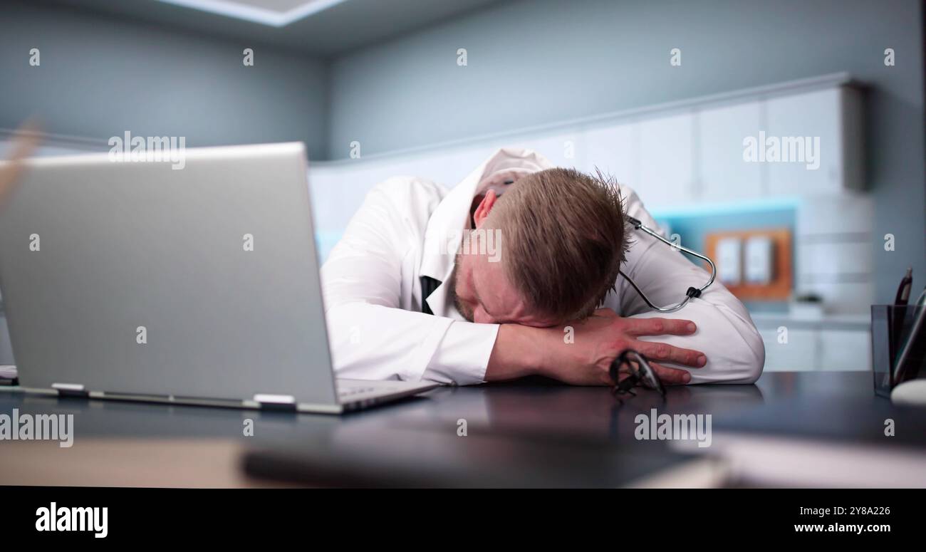 Annoiato medico medico uomo che dorme. Dipendente stanco e riposante Foto Stock