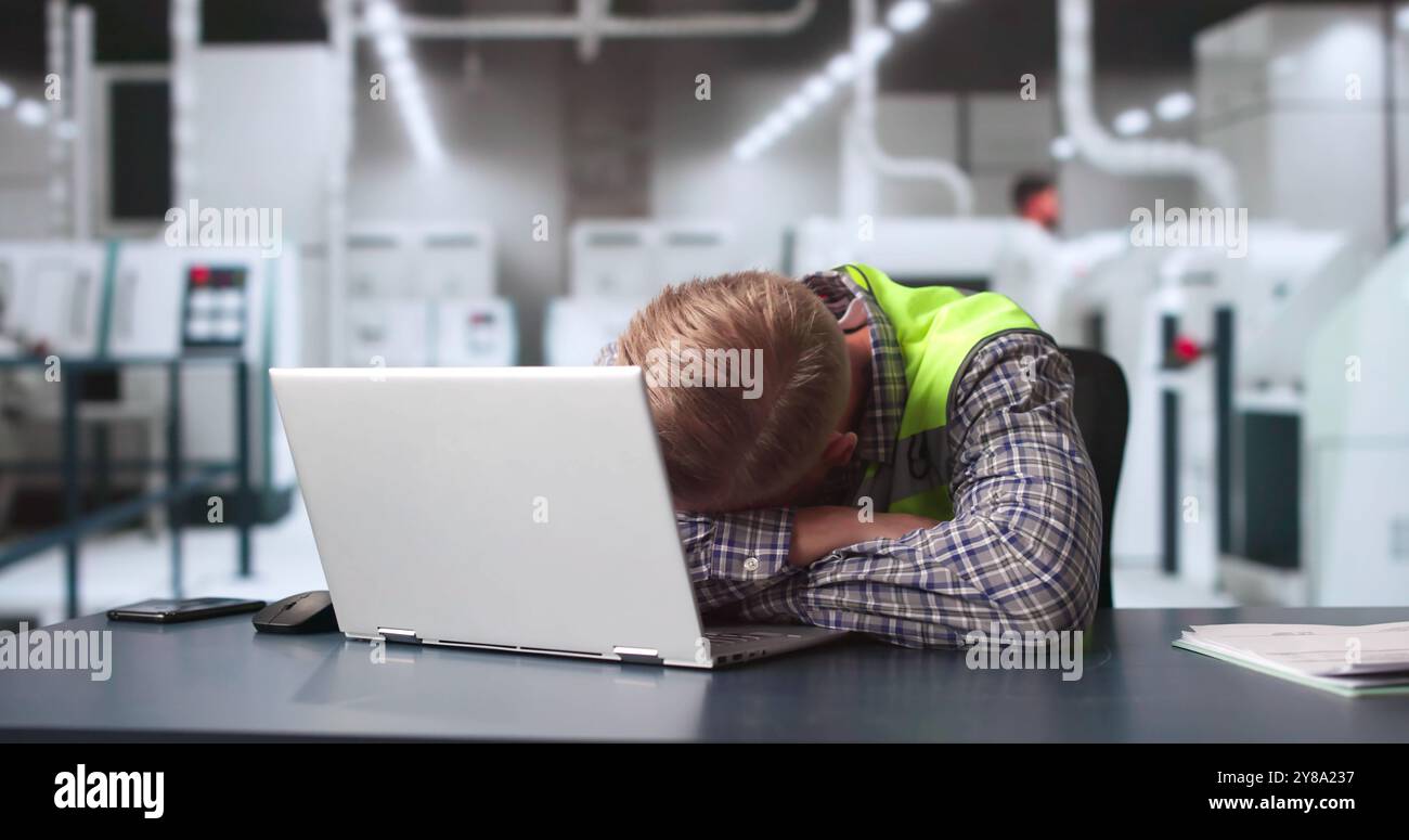 Uomo annoiato che dorme al lavoro. Narcolessia e privazione del sonno Foto Stock