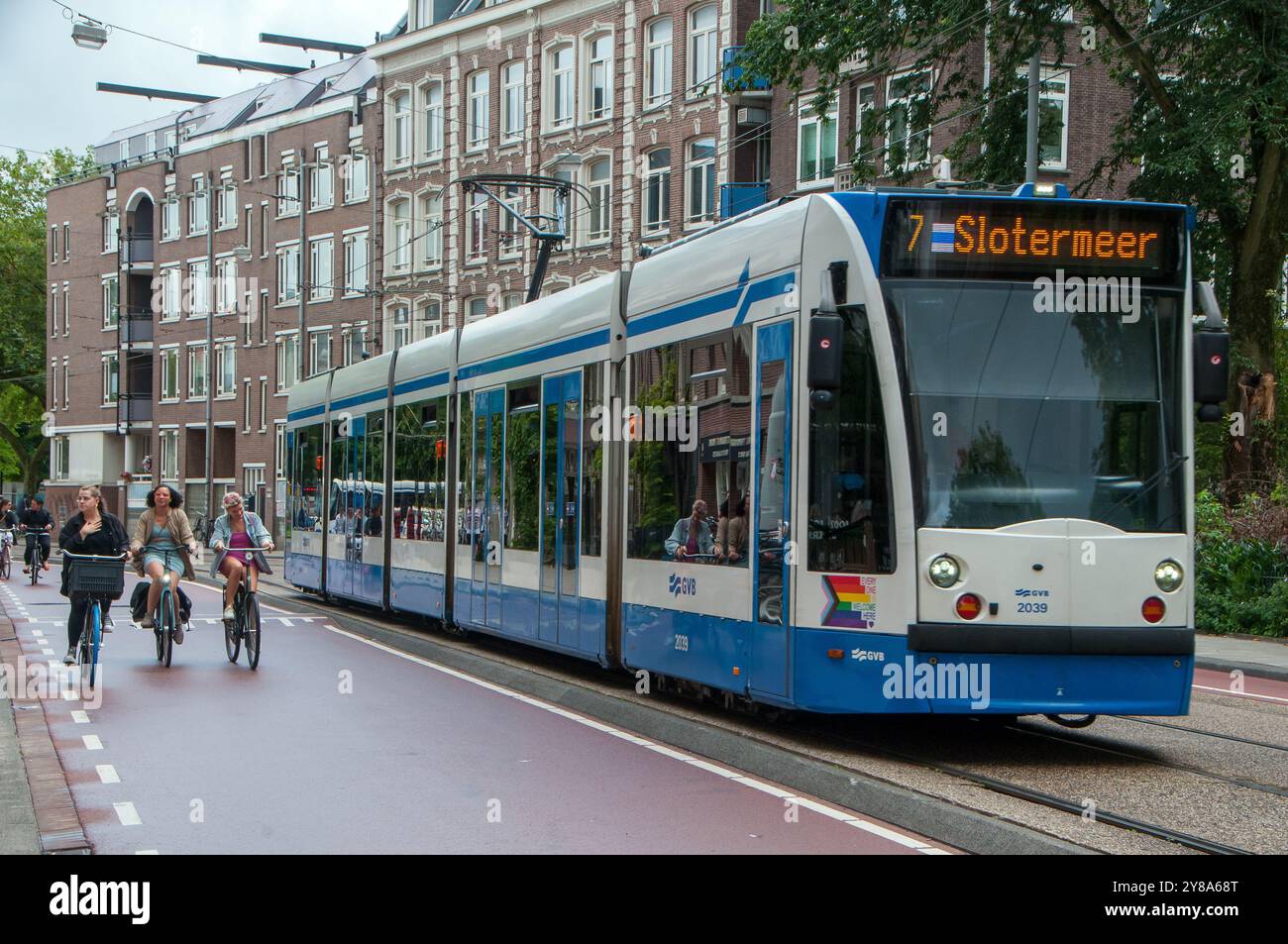Donne in bicicletta con tram ad Amsterdam / donne in bicicletta con tram ad Amsterdam Foto Stock