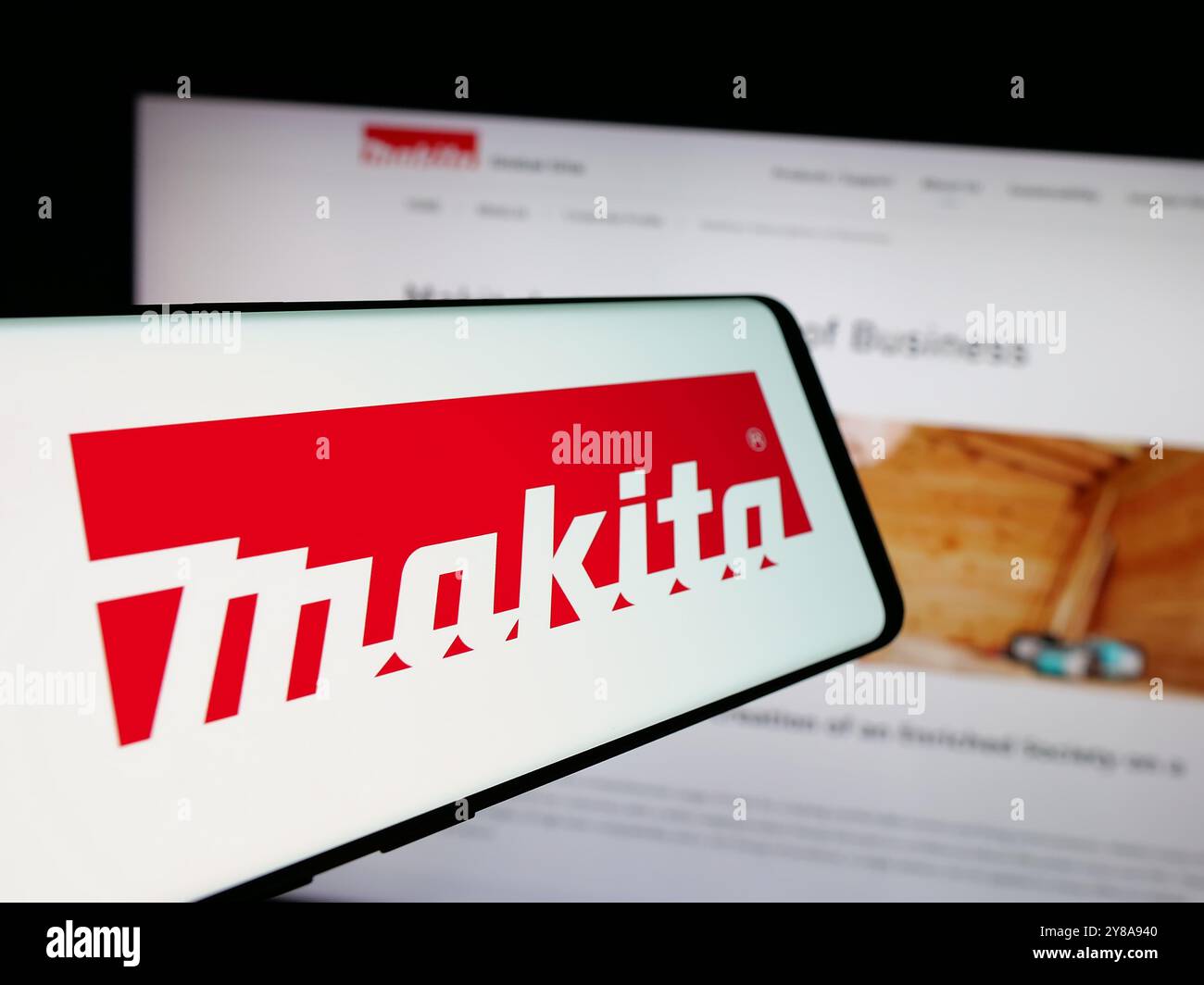 Smartphone con logo della società giapponese di utensili elettrici Makita Corporation sullo schermo di fronte al sito Web aziendale. Messa a fuoco al centro del display del telefono. Foto Stock