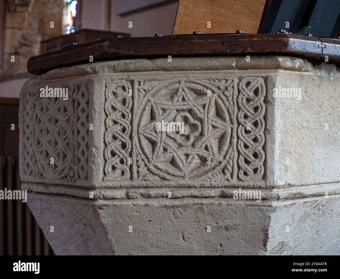Font ottagonale del XII secolo con rosoni e decorazioni interlacciate, chiesa di tutti i Santi, Mears Ashby, Northamptonshire, Regno Unito Foto Stock
