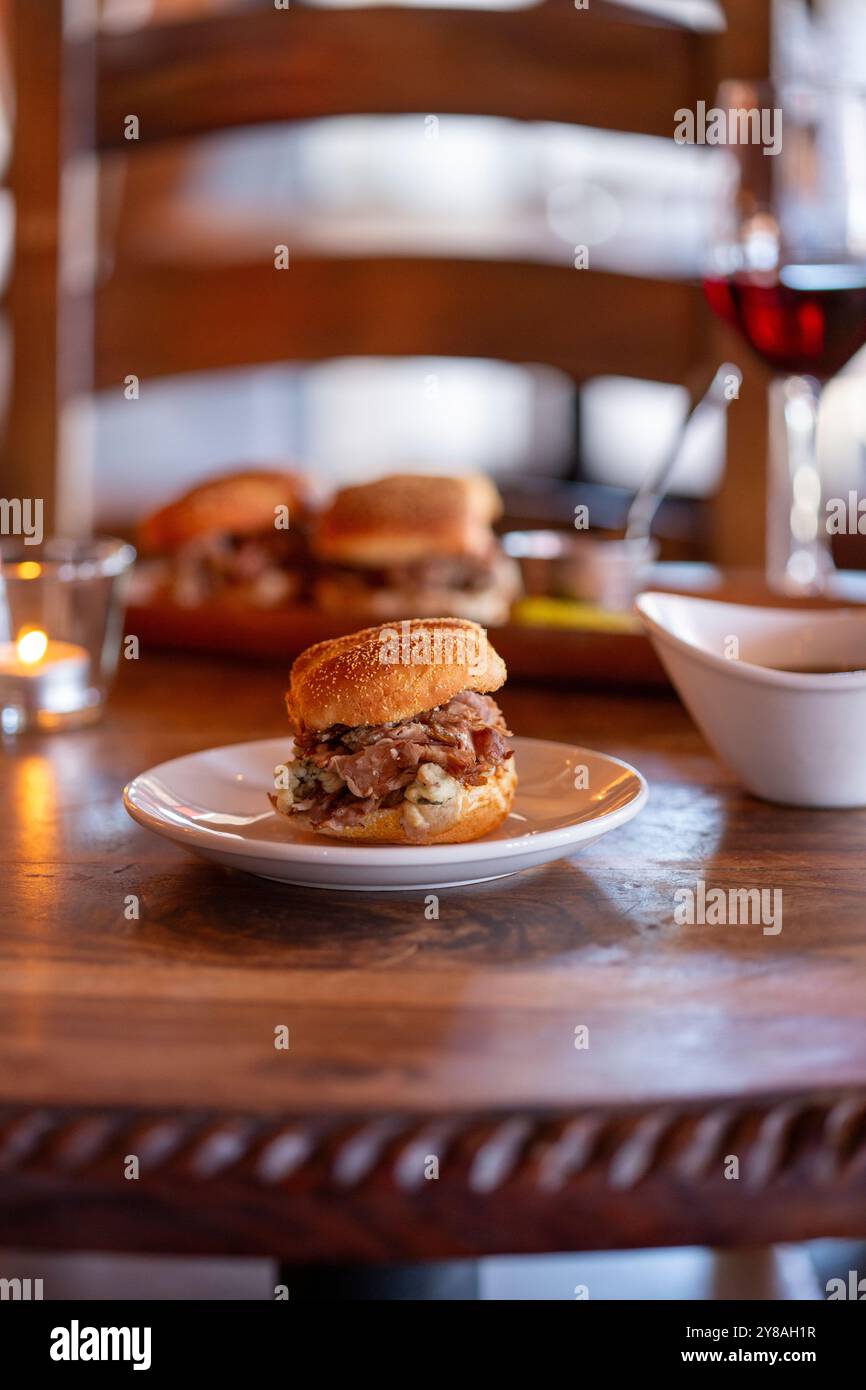 Un panino con panino di roast beef su un tavolo di legno verticale Foto Stock