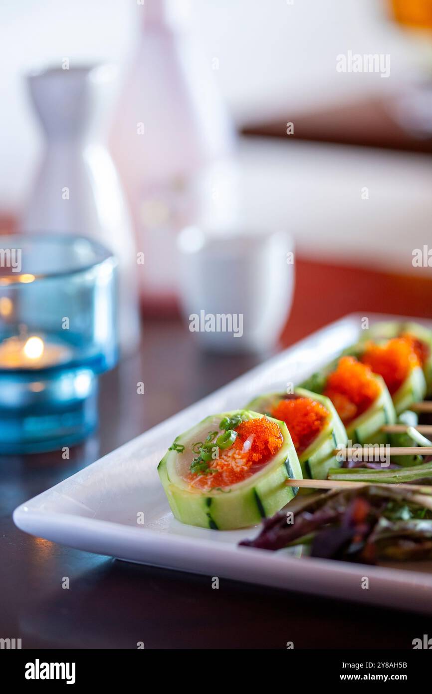 Rotolo di sushi avvolto in cetrioli in verticale Foto Stock