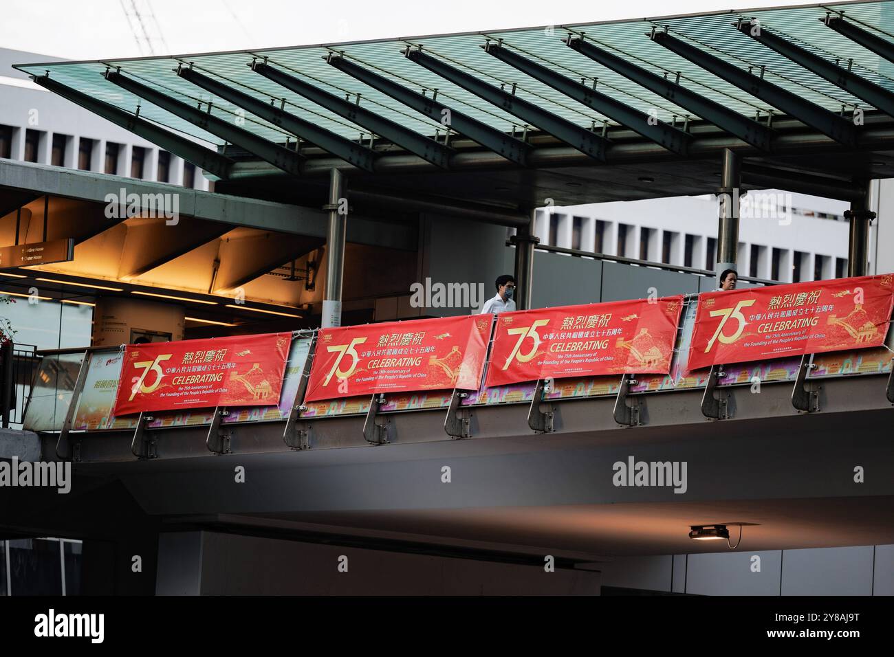 Hong Kong, Cina. 3 ottobre 2024. La gente passa davanti agli striscioni delle celebrazioni durante la "settimana d'oro" della giornata nazionale di Hong Kong. Per celebrare il 75° anniversario della fondazione della Repubblica Popolare Cinese il 1° ottobre 2024, sono stati introdotti una varietà di sconti e attrazioni per attrarre sia turisti che gente del posto durante le celebrazioni. Credito: SOPA Images Limited/Alamy Live News Foto Stock