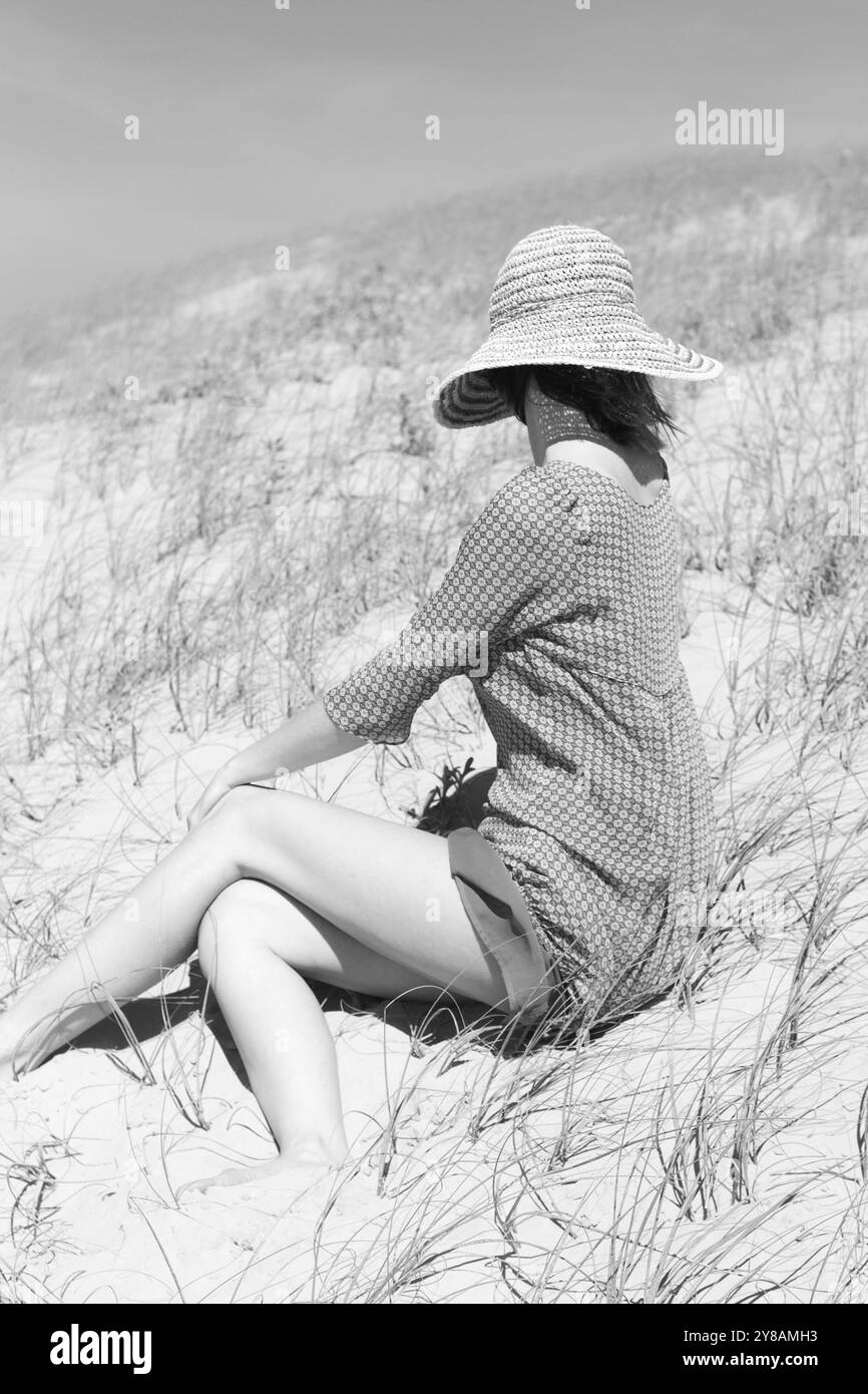 donna con capelli corti e cappello da sole sulle dune Foto Stock