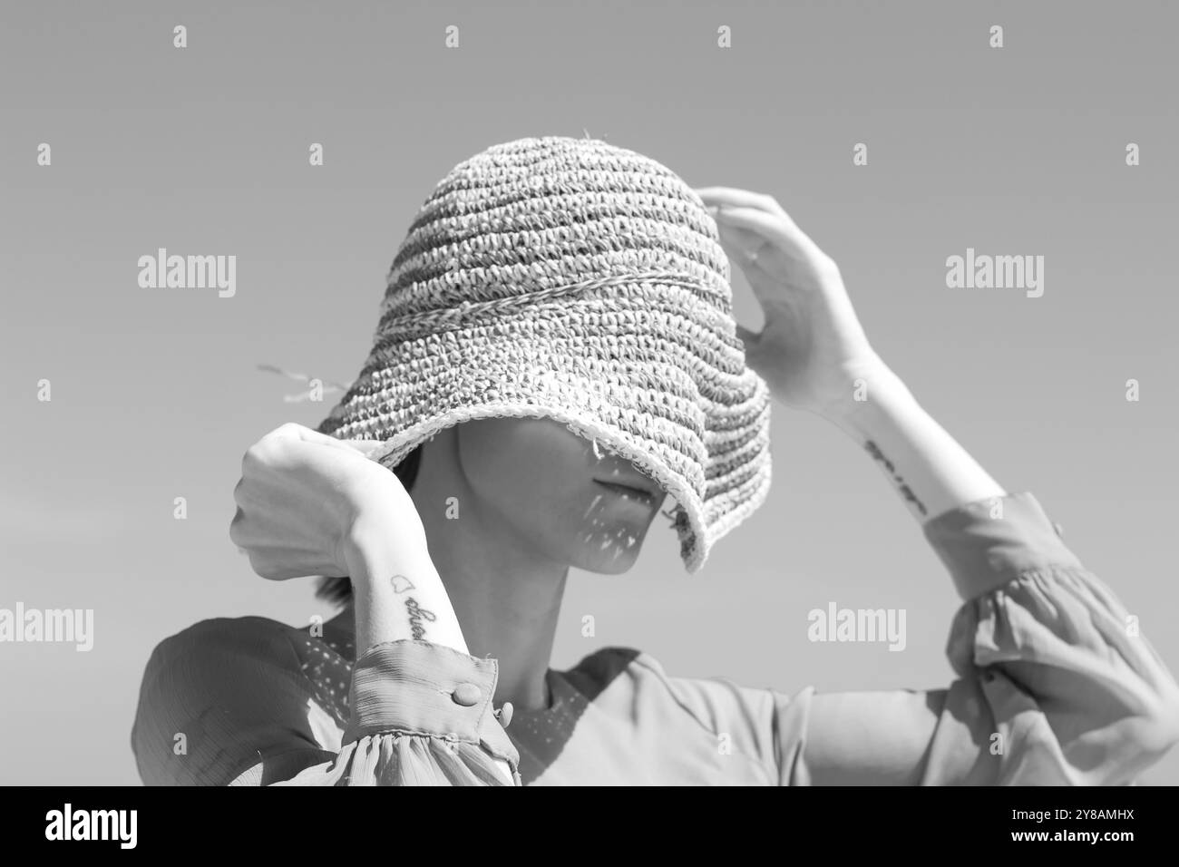 donna con capelli corti e cappello da sole sulle dune Foto Stock