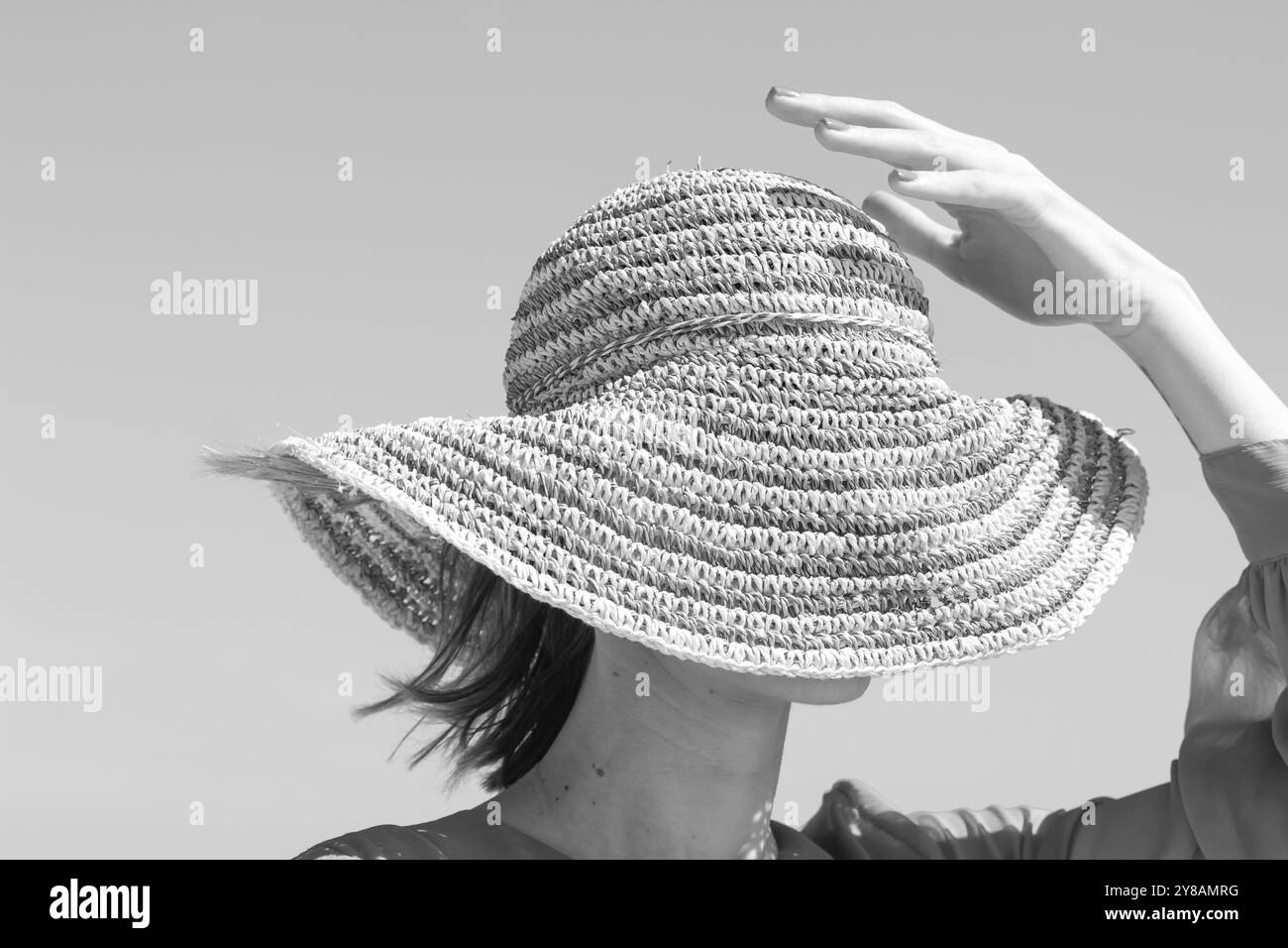 donna con capelli corti e cappello da sole sulle dune Foto Stock