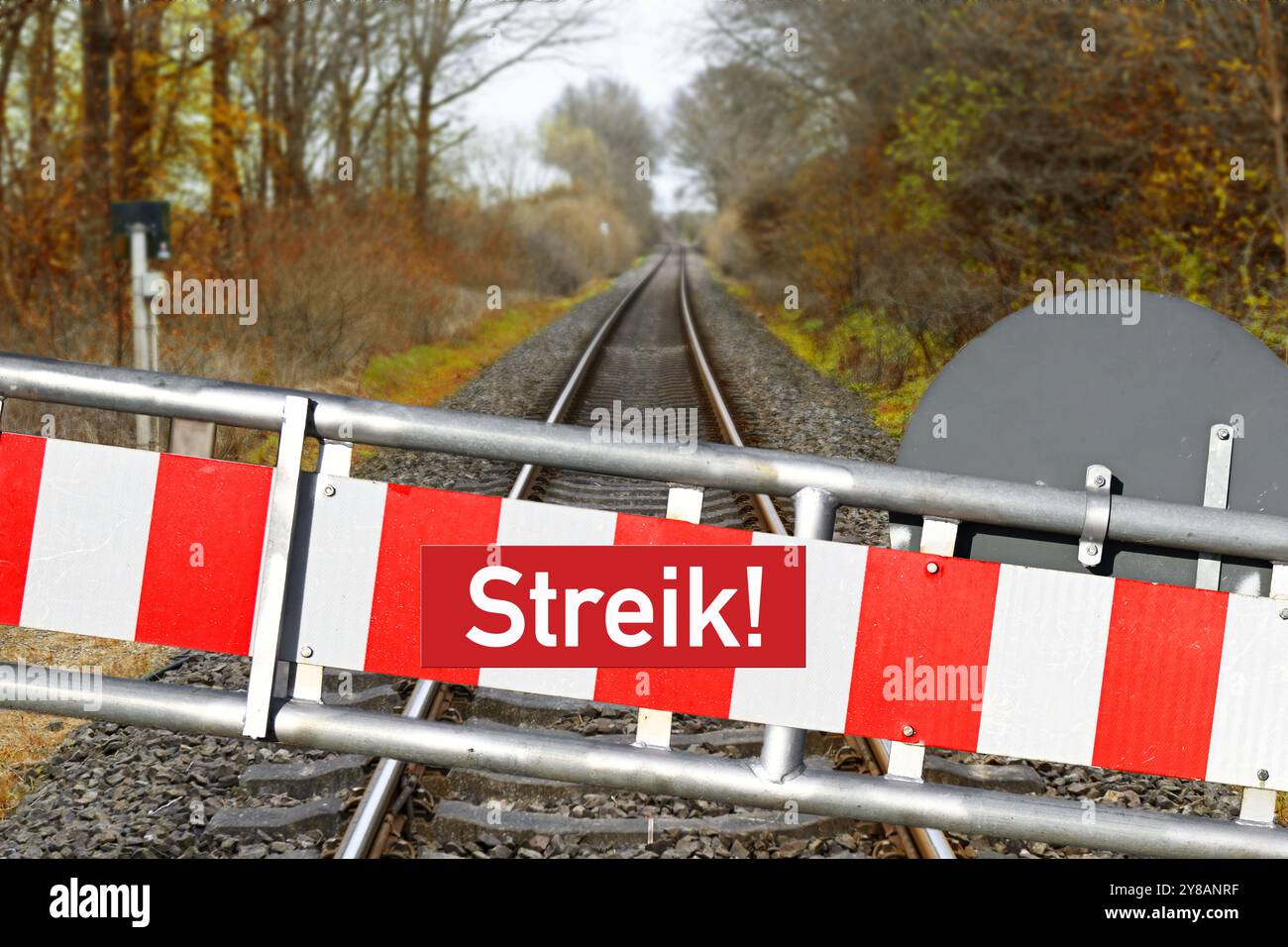 MONTAGGIO FOTOGRAFICO, barriera con l'iscrizione Strike davanti a binari ferroviari vuoti, foto simbolica dello sciopero GDL, FOTOMONTAGE, Schranke mit Aufschrift S. Foto Stock