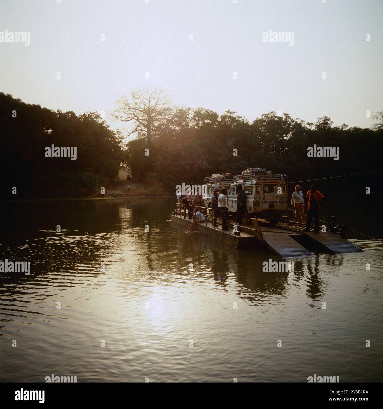 Eine Touristengruppe überquert mit zwei Jeeps auf einem Floß einen Fluss, Ghana um 1984. 90020000009 Foto Stock