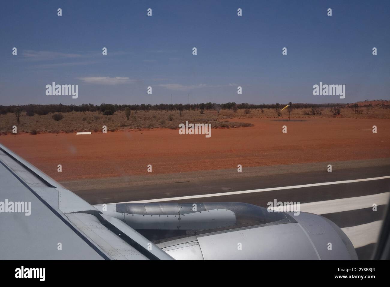 Decollo dall'aeroporto di Ayers Rock, dall'aeroporto Connellan a Yulara, Uluru, Australia centrale, vista della pista e del deserto rosso da un posto sull'ala Foto Stock