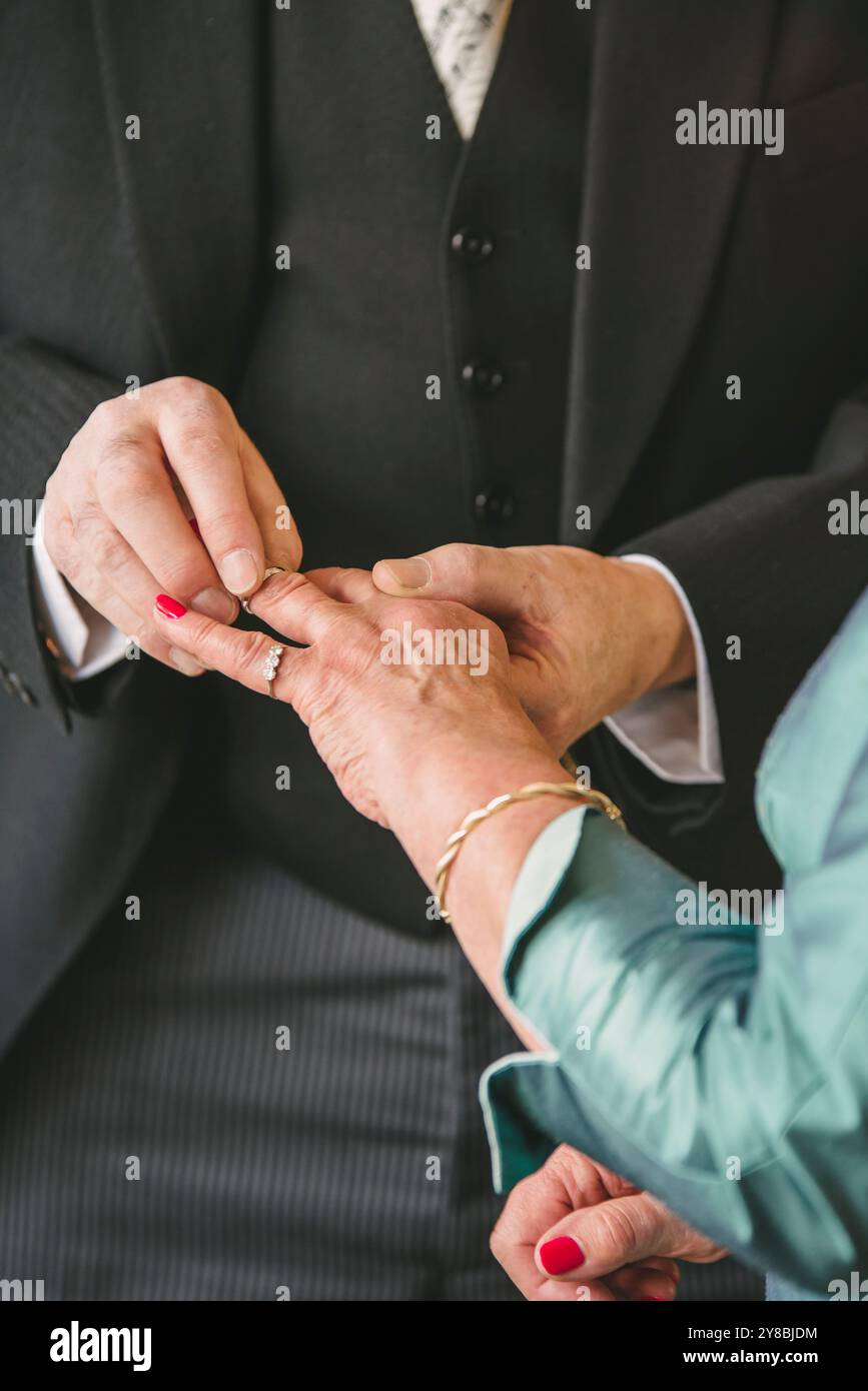 Un capo anziano che mette l'anello sulla mano delle spose Foto Stock