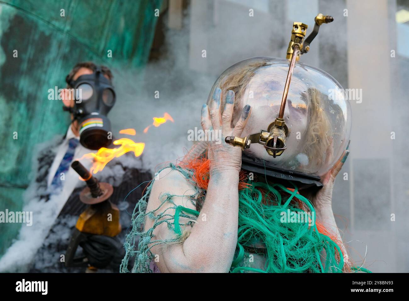 Londra, Regno Unito, 4 ottobre 2024. Ocean Rebellion ha messo in scena una spettacolare protesta di perfomance con una dea dell'oceano "annegando nel petrolio" nell'ultimo giorno delle riunioni del Comitato per la protezione dell'ambiente marino (MEPC) tenutesi presso l'Organizzazione marittima internazionale (IMO). Hanno ricordato agli stati membri delle Nazioni Unite le loro responsabilità nei confronti dell'ambiente marino e hanno evidenziato i danni del gas naturale liquido (GNL) utilizzato nell'industria navale, sottolineando che le perdite di metano dalle navi sono ottanta volte più dannose per l'anidride carbonica. Credito: Fotografia dell'undicesima ora/Alamy Live News Foto Stock