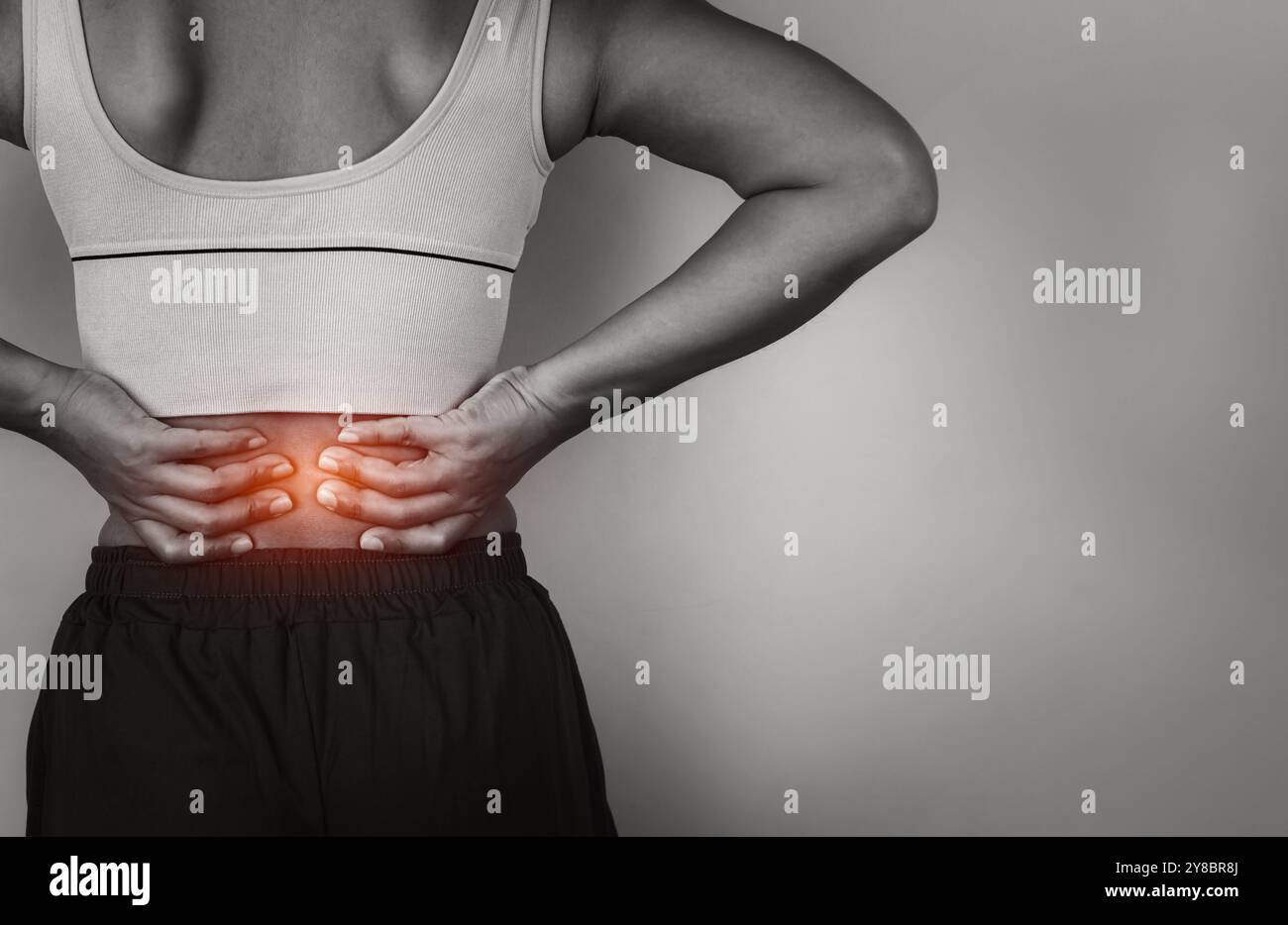 Donna con dolore acuto una schiena su sfondo grigio, malattia schiena e colonna vertebrale, donna che massaggia il suo spasmo muscolare schiena, assistenza sanitaria e concetto medico, Injur Foto Stock