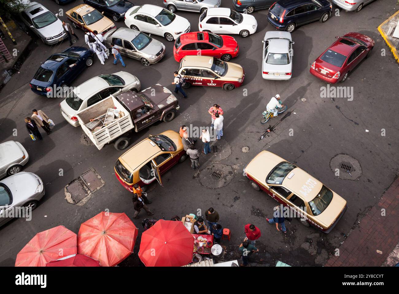 Vista dall'alto del traffico caotico dell'ora di punta al mattino presto all'incrocio di strade. I tassisti chiacchierano, bloccando l'angolo di Roma, città del Messico Foto Stock