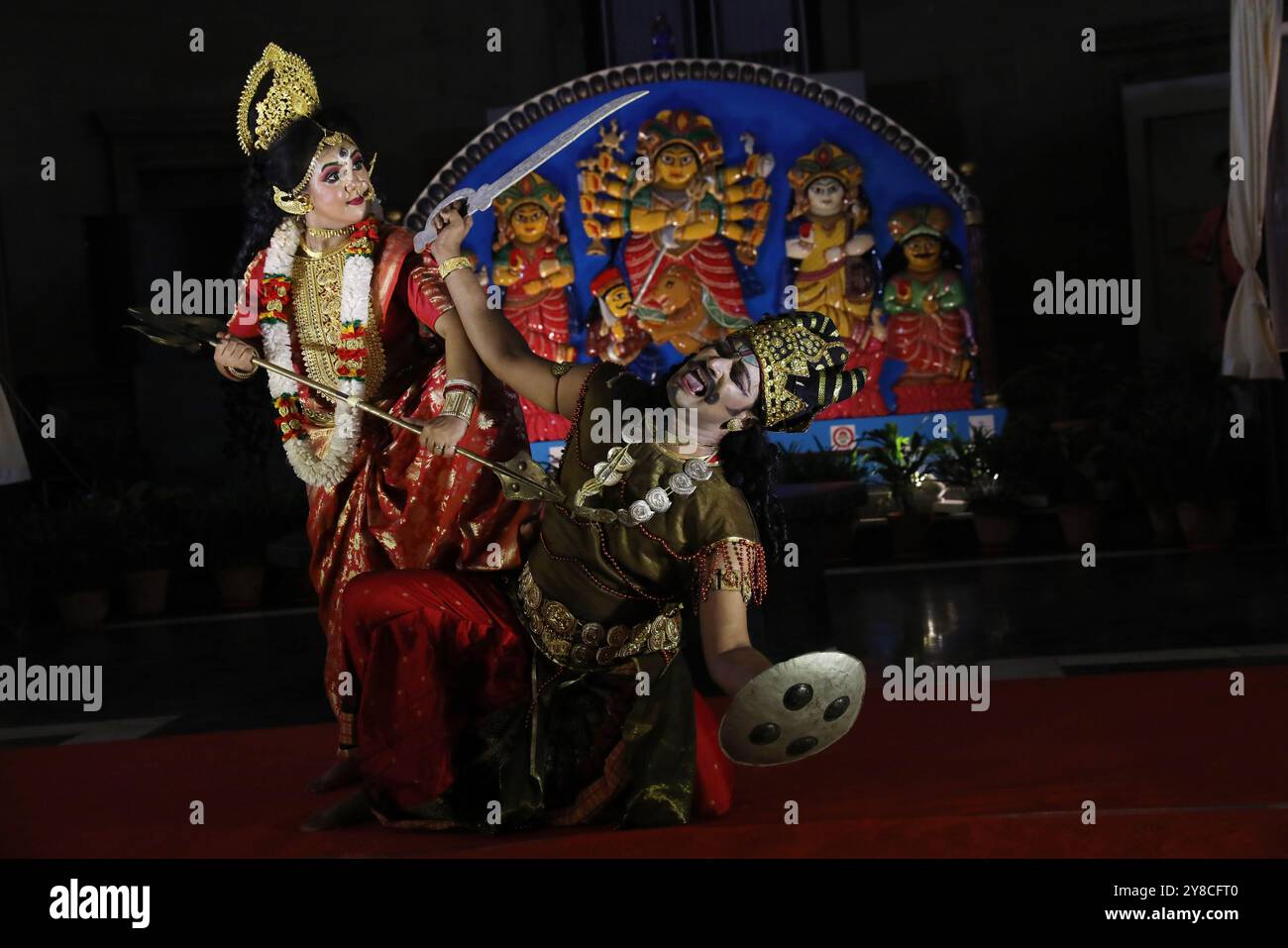 I ballerini eseguono la danza ''Durgotsab'' vestita da dea Durga e da demone prima del festival Durga Puja all'interno dello storico monumento Victoria Memorial, costruito durante il dominio coloniale britannico, di fronte a un idolo Durga di legno, a Kolkata, in India, il 4 ottobre 2024. L'annuale Durga Puja Festival, che inizia il 9 ottobre e termina il 13 ottobre, è uno dei festival più popolari per gli indù. Nella mitologia indù, la dea indù Durga simboleggia il potere e il trionfo del bene sul male. (Foto di Rupak De Chowdhuri/NurPhoto) Foto Stock