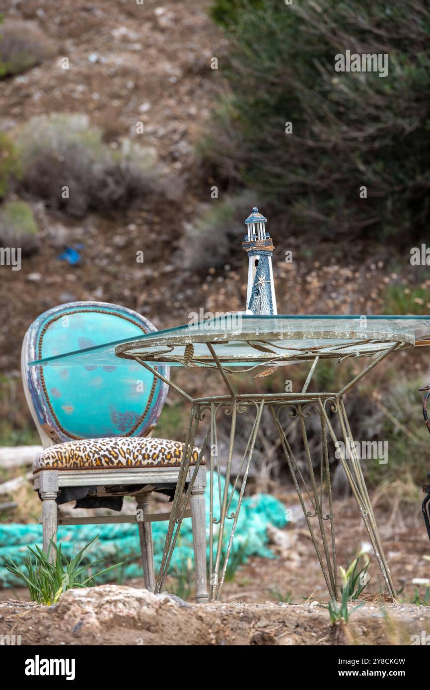 Tavoli e sedie d'epoca arrugginiti in stile francese su una spiaggia in Grecia utilizzata dai turisti per sedersi, rilassarsi e godersi il paesaggio costiero della spiaggia di Dafni Foto Stock