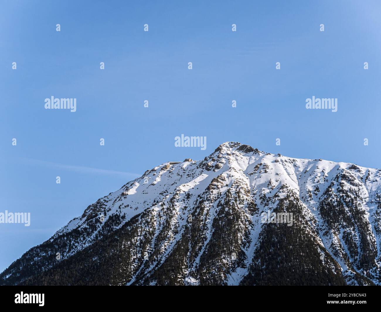 Una splendida vista sulla cima innevata del Serre Chevalier di Brianza, su un cielo azzurro e limpido. L'aspro paesaggio montano ne mette in mostra la bellezza Foto Stock