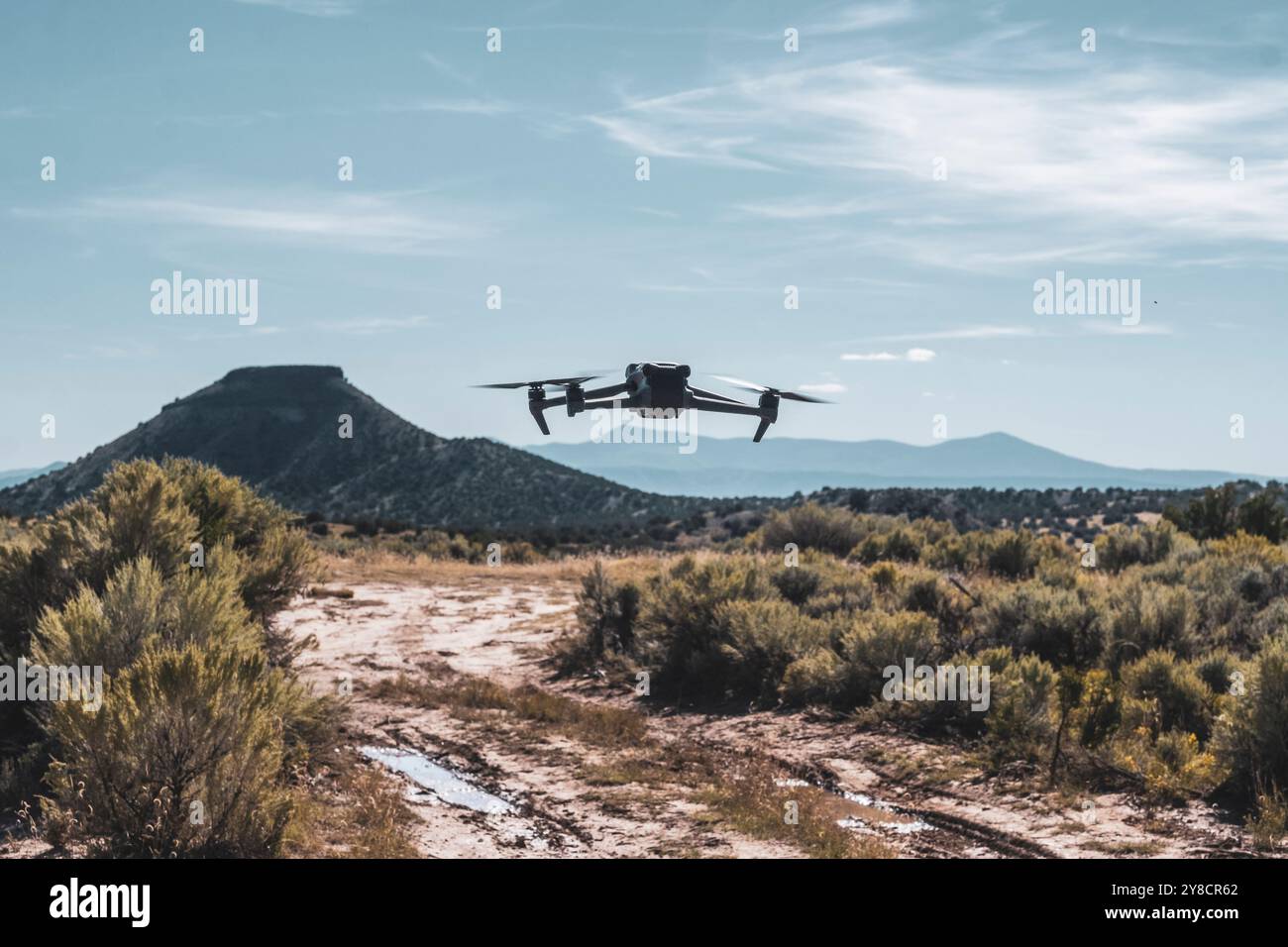 Un drone DJI Mavic 3 Classic che si libra su una strada sterrata nel sud-ovest americano Foto Stock