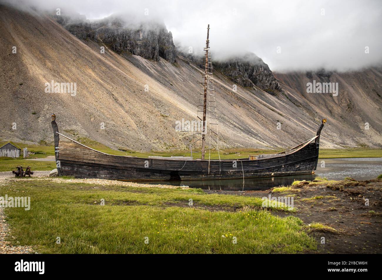 Vecchia barca vichinga in legno arenata sul fiordo in islanda Foto Stock