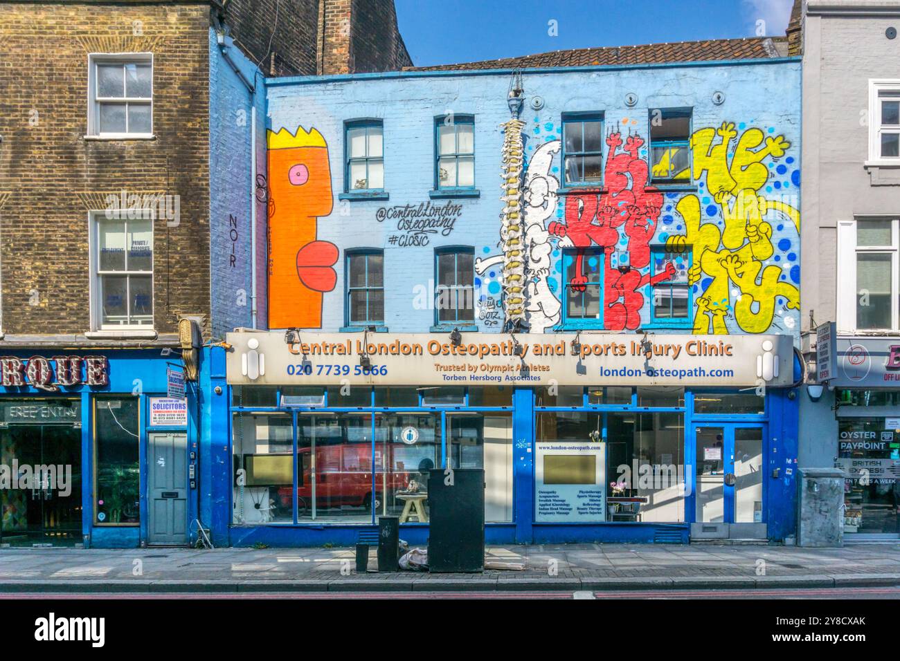 Centro di Londra Osteopathy and Sports Injury Clinic in Old Street, Hackney. La facciata dell'edificio è coperta da murales di Street art. Foto Stock
